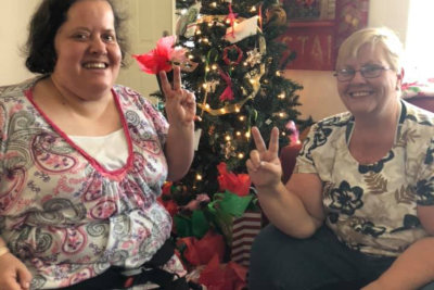 two seniors smiling with peace sign